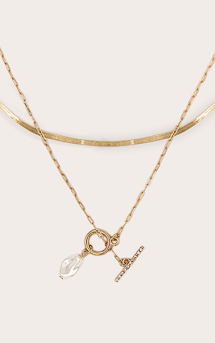 https://cdn-img.prettylittlething.com/6/b/7/0/6b709fe1b31eb17d9344a46a88be66e23e4dabc3_CNN3217_2_gold_layered_t_bar_necklace_with_pearl_detail.jpg