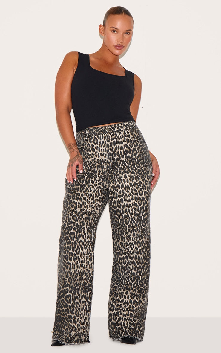 https://cdn-img.prettylittlething.com/7/a/b/5/7ab537868f7a84f5b8b7f61e51d28c66097c6bd5_CNI8843_1_plus_brown_leopard_print_denim_wide_leg_denim_jean.jpg
